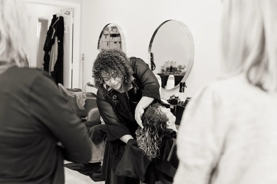 Caroline Smalley working through a client's damp curls while stylists watch at a Curl Identity education day